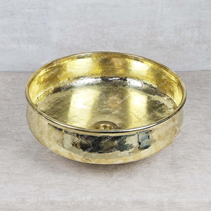 Gold metallic bowl on a light gray background