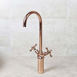 Rose gold kitchen faucet on a light gray background