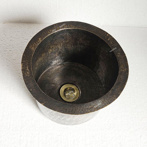 Bronze sink with a textured surface on a white background
