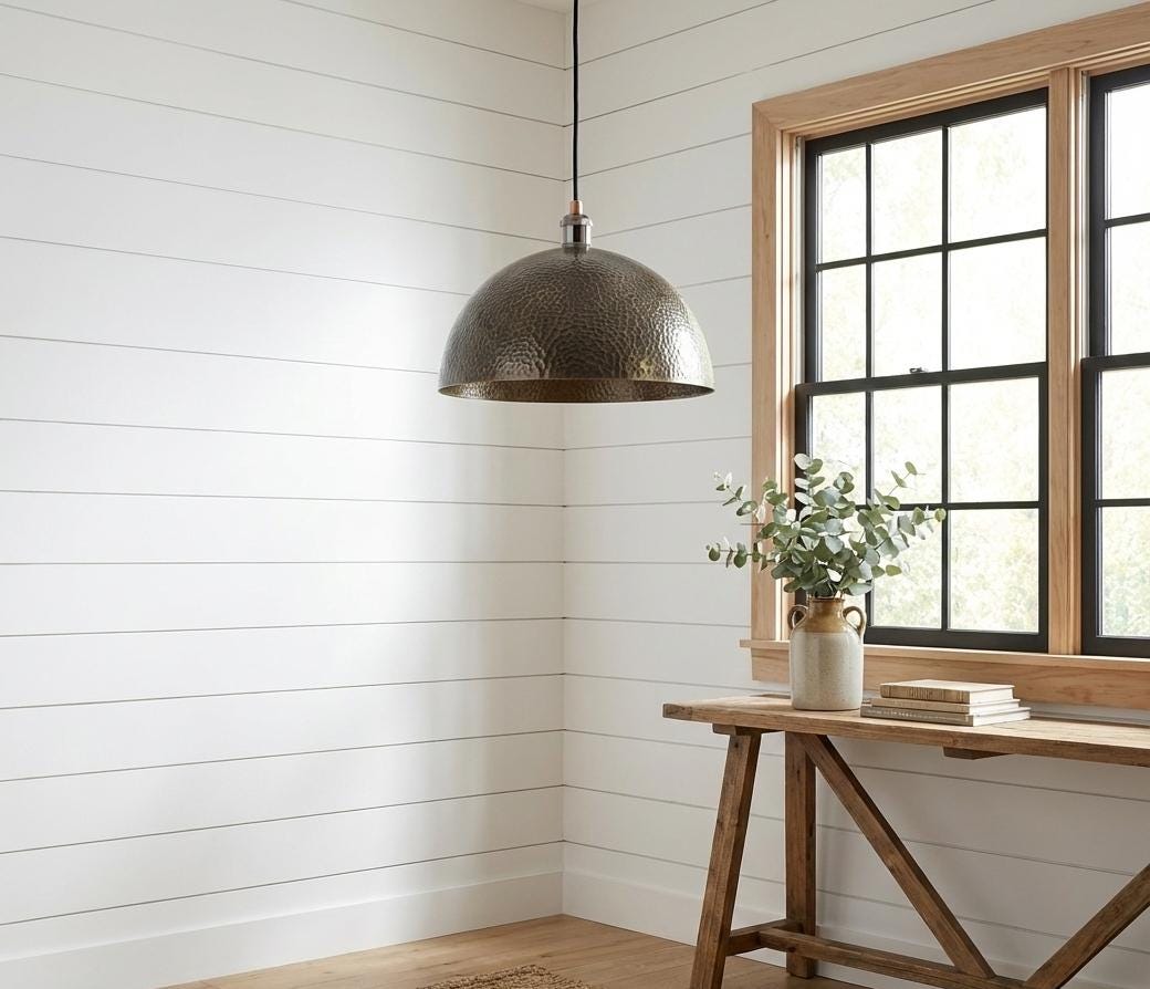 Nestled corner with a pendant light, wooden table, and window with black frames.