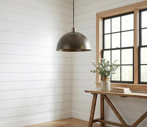 Nestled corner with a pendant light, wooden table, and window with black frames.