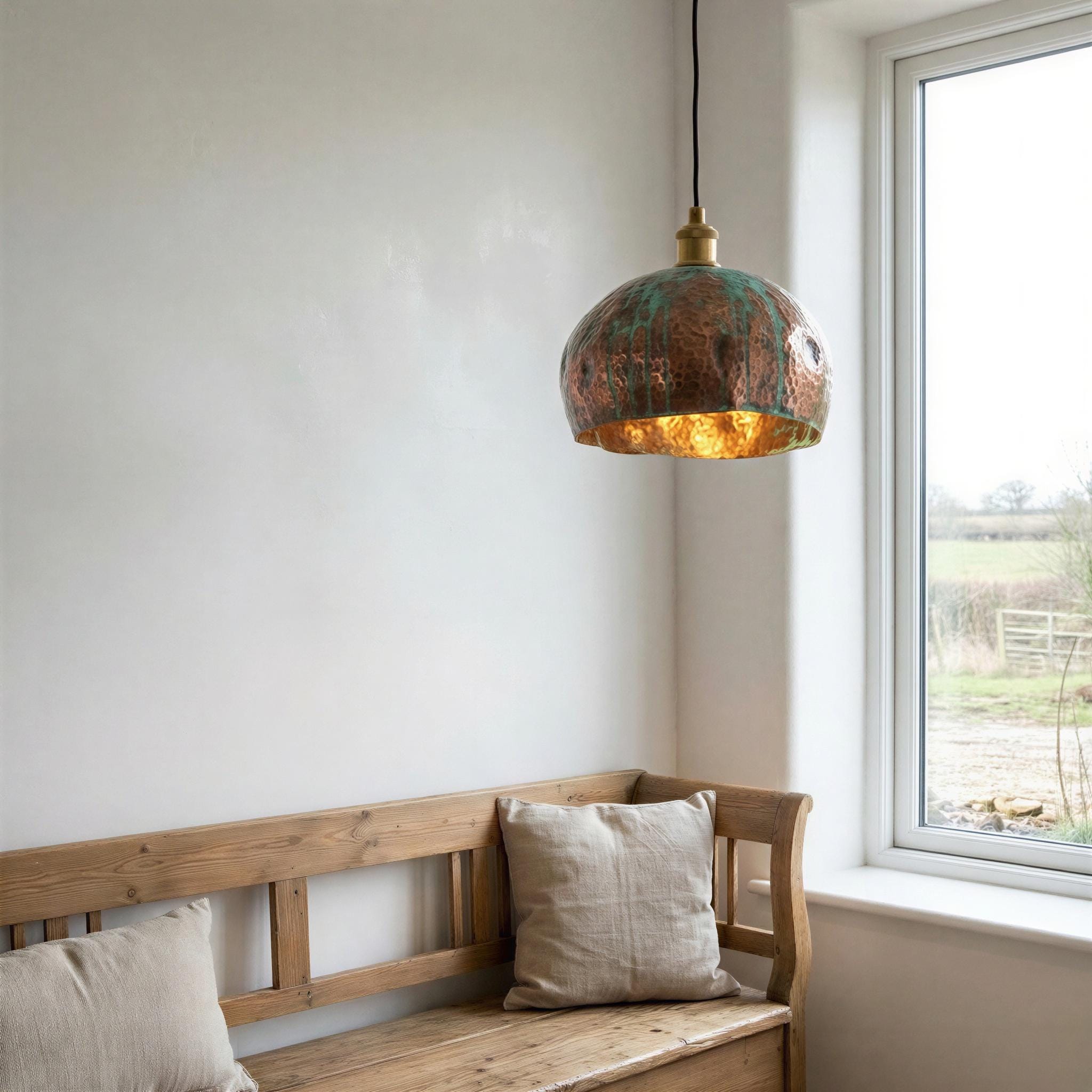 Wooden bench with pillows under a pendant light near a window