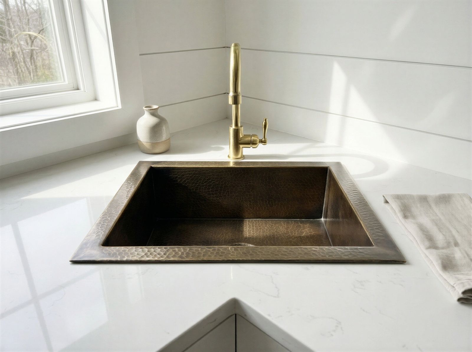 Modern kitchen sink with gold faucet in a bright room