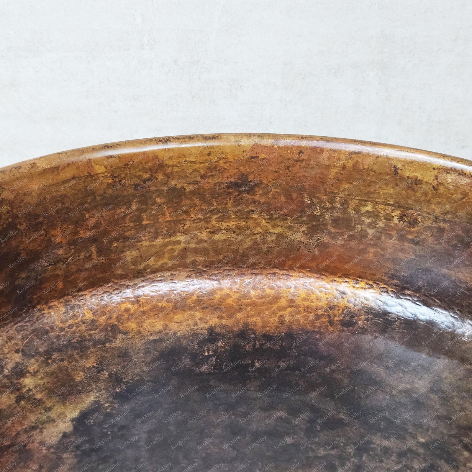 Close-up of a tarnished metal bowl on a light gray background
