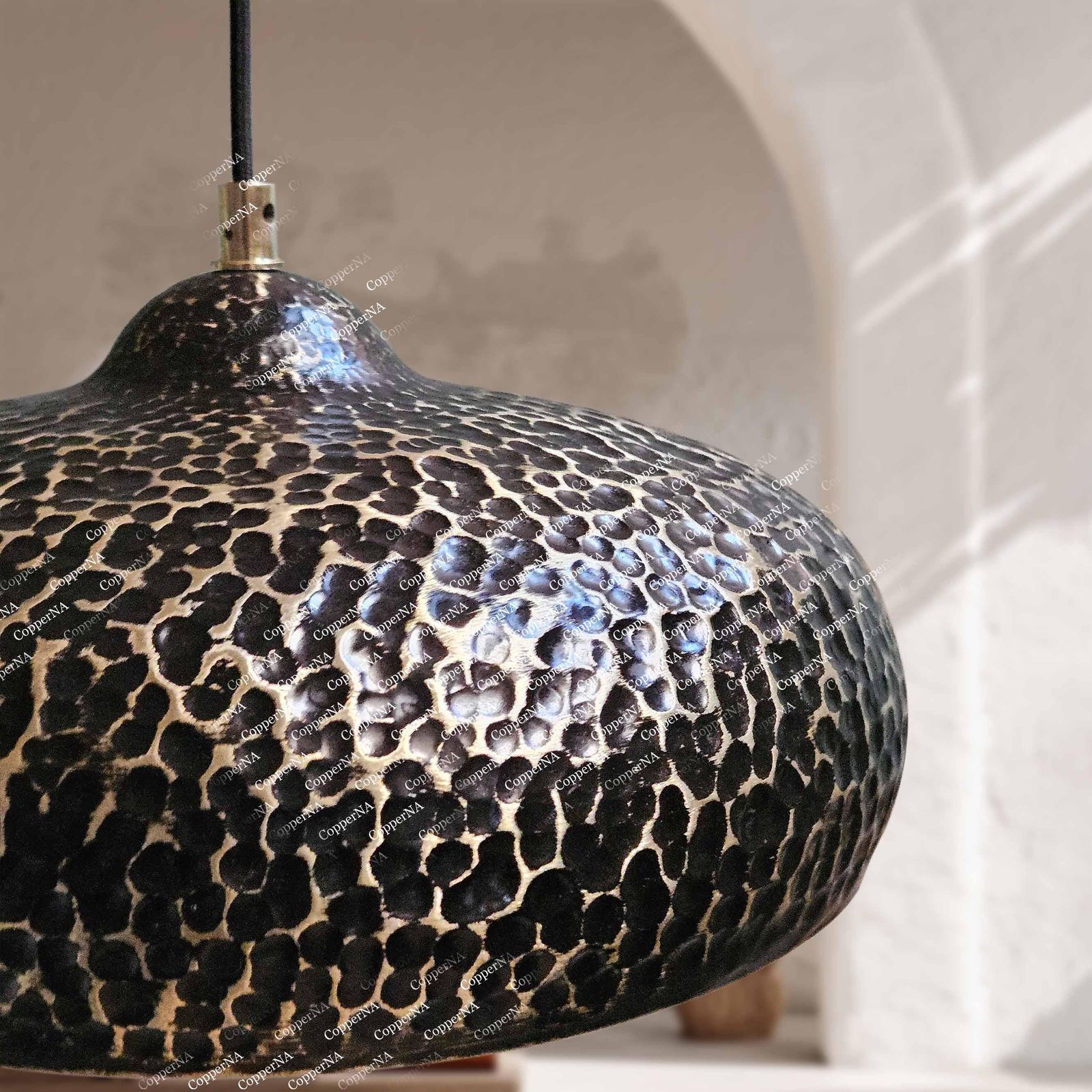Rustic metal ceiling light fixture with a textured black and gold finish in a modern living room setting.