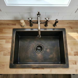 kitchen sink with bronze faucet on a wooden countertop