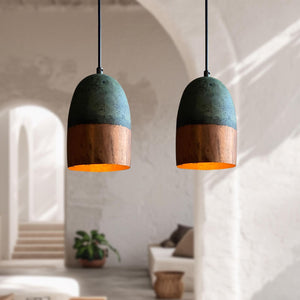 Two pendant lights with green and copper design hanging in a room.