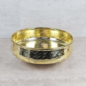 Gold bowl with engraved text on a light gray background