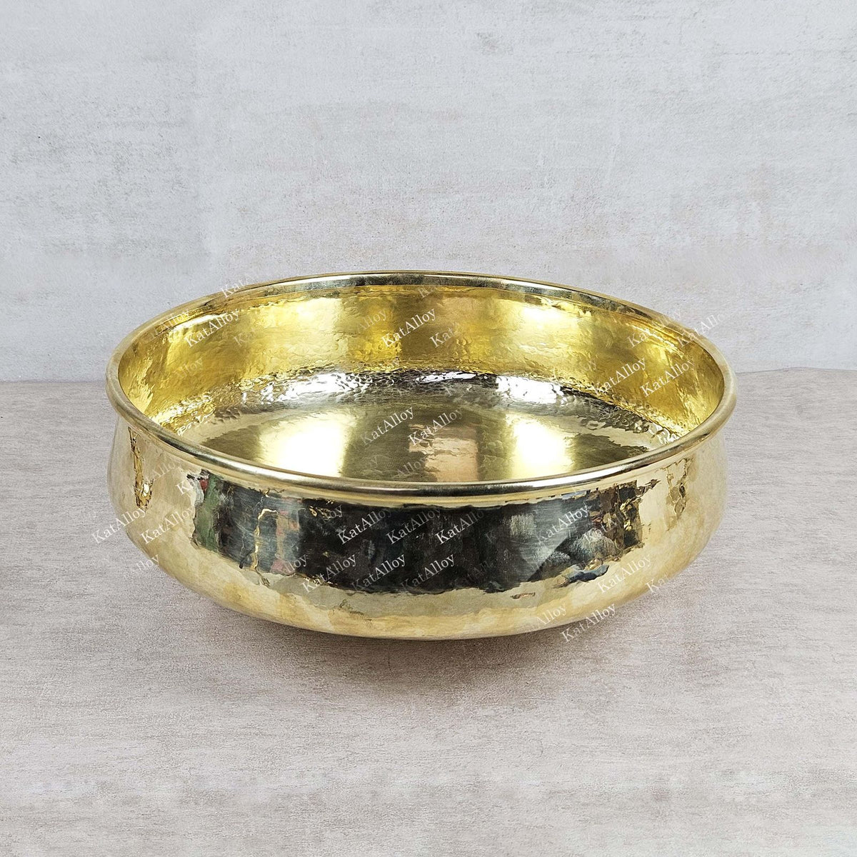 Gold bowl with engraved text on a light gray background