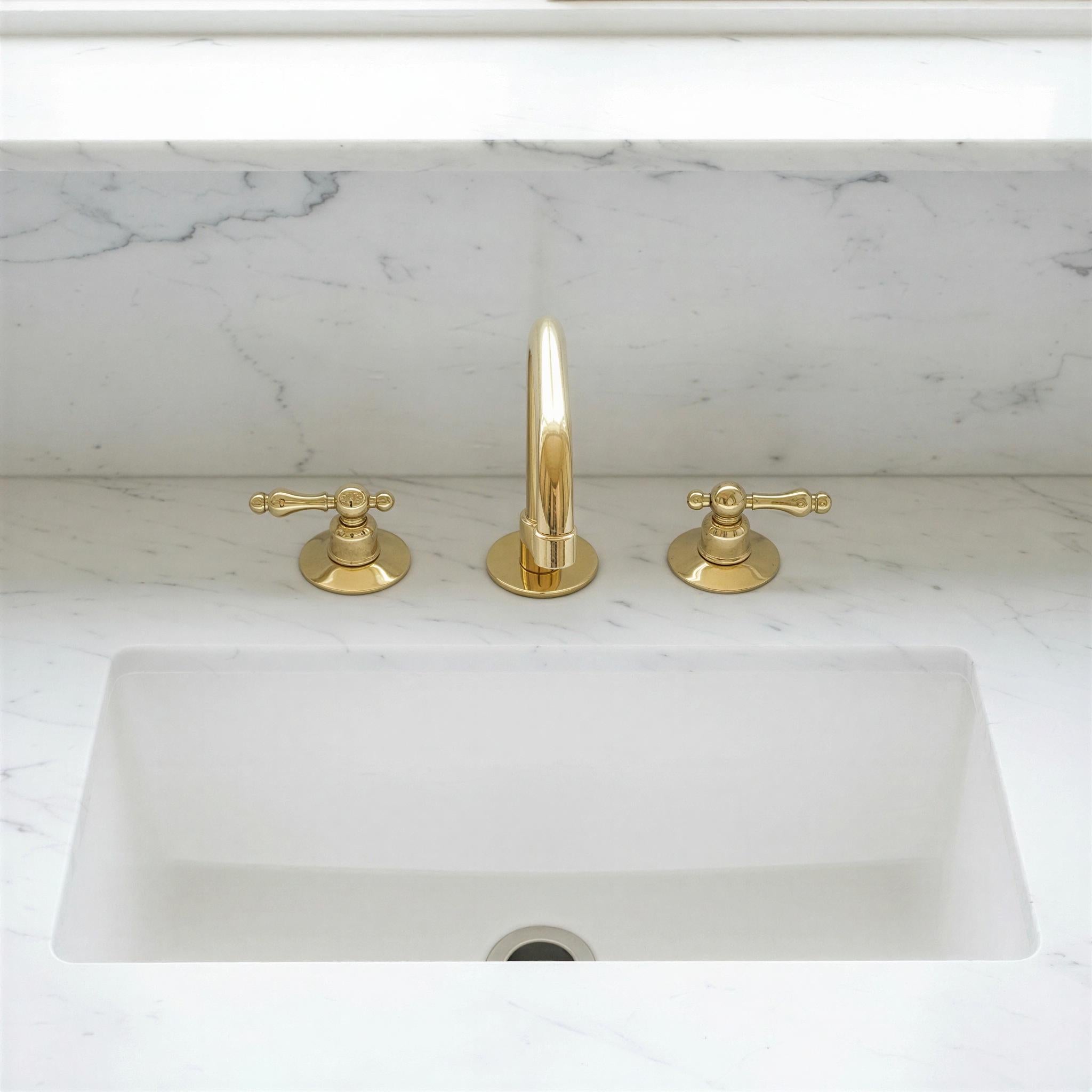 Gold faucet and handles on a marble countertop
