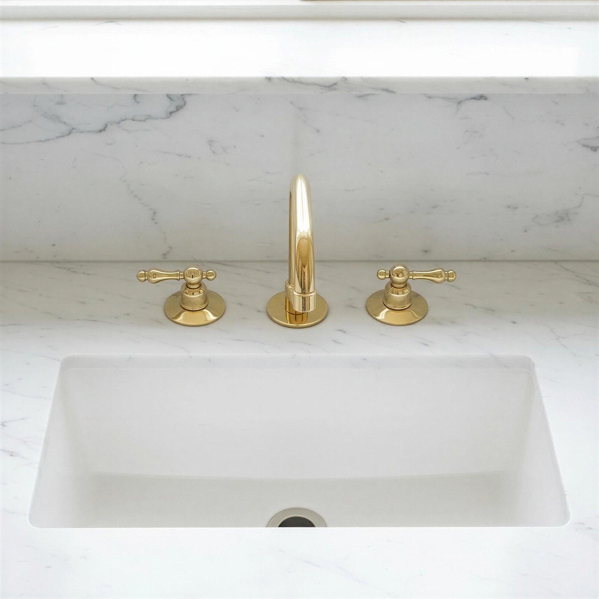 Gold faucet and handles on a marble countertop