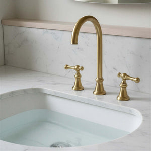 Gold faucet and handles on a marble sink