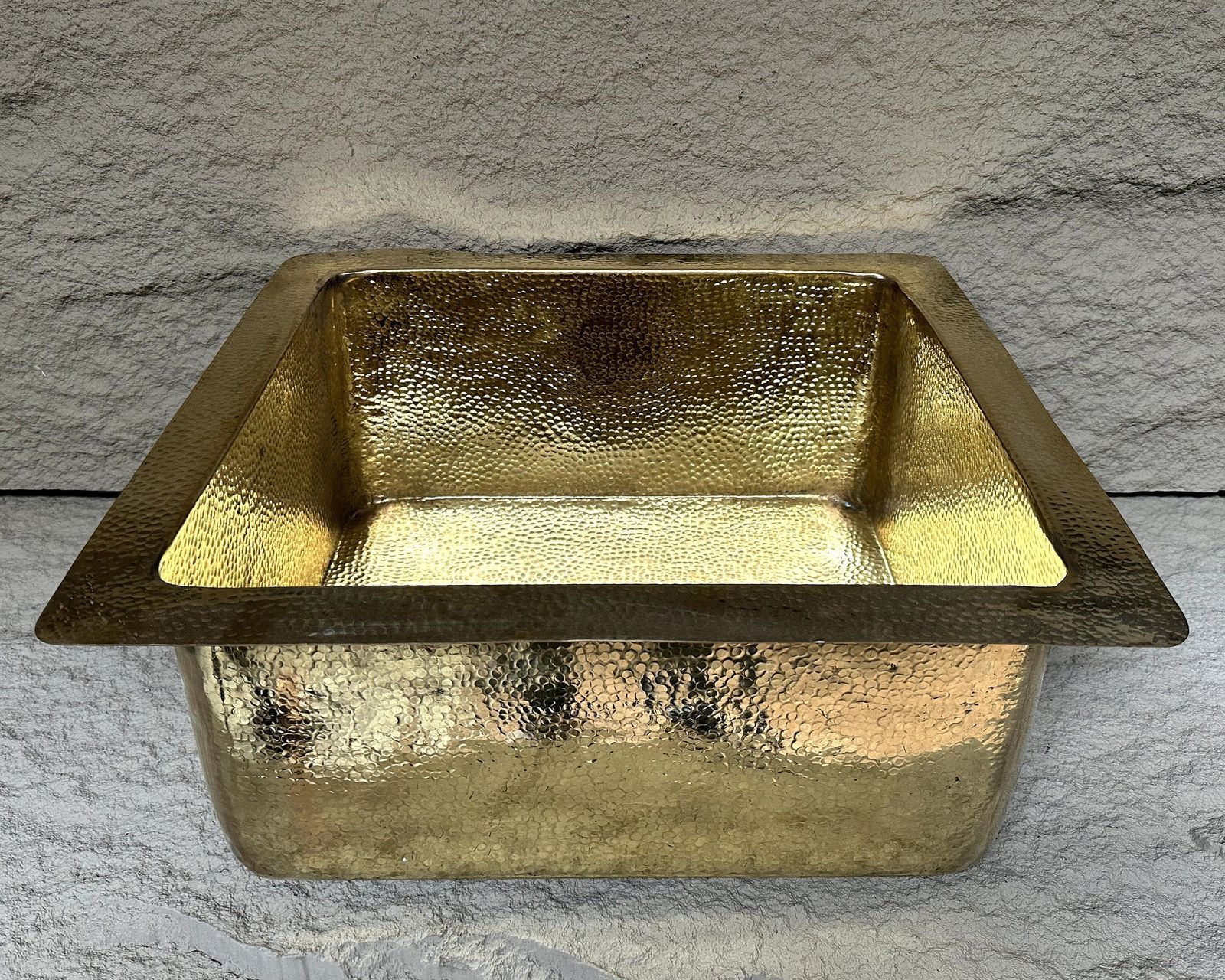 Gold metal basin on a textured gray background