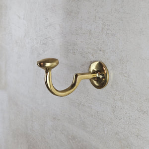 Gold wall hook on a gray concrete wall