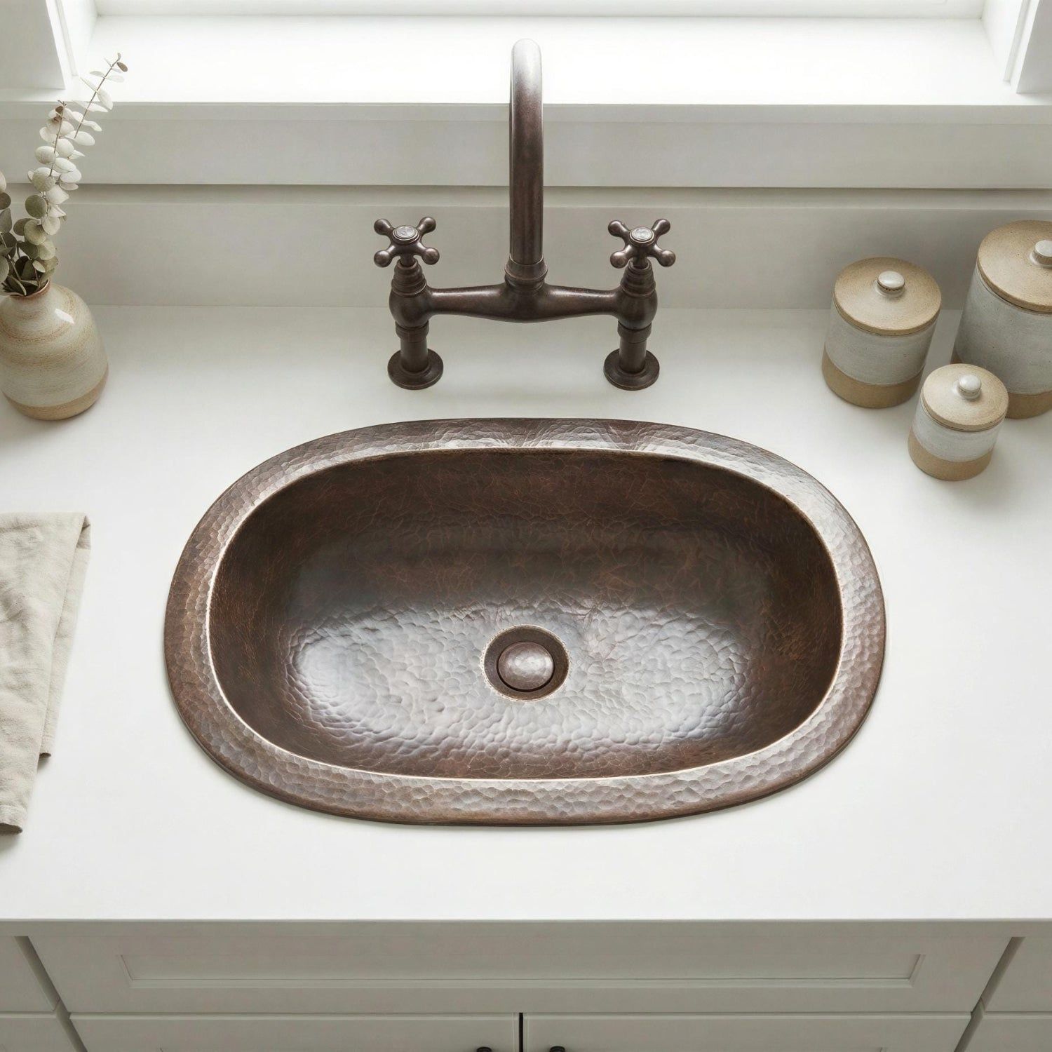 Brass sink with bronze faucet on a white countertop