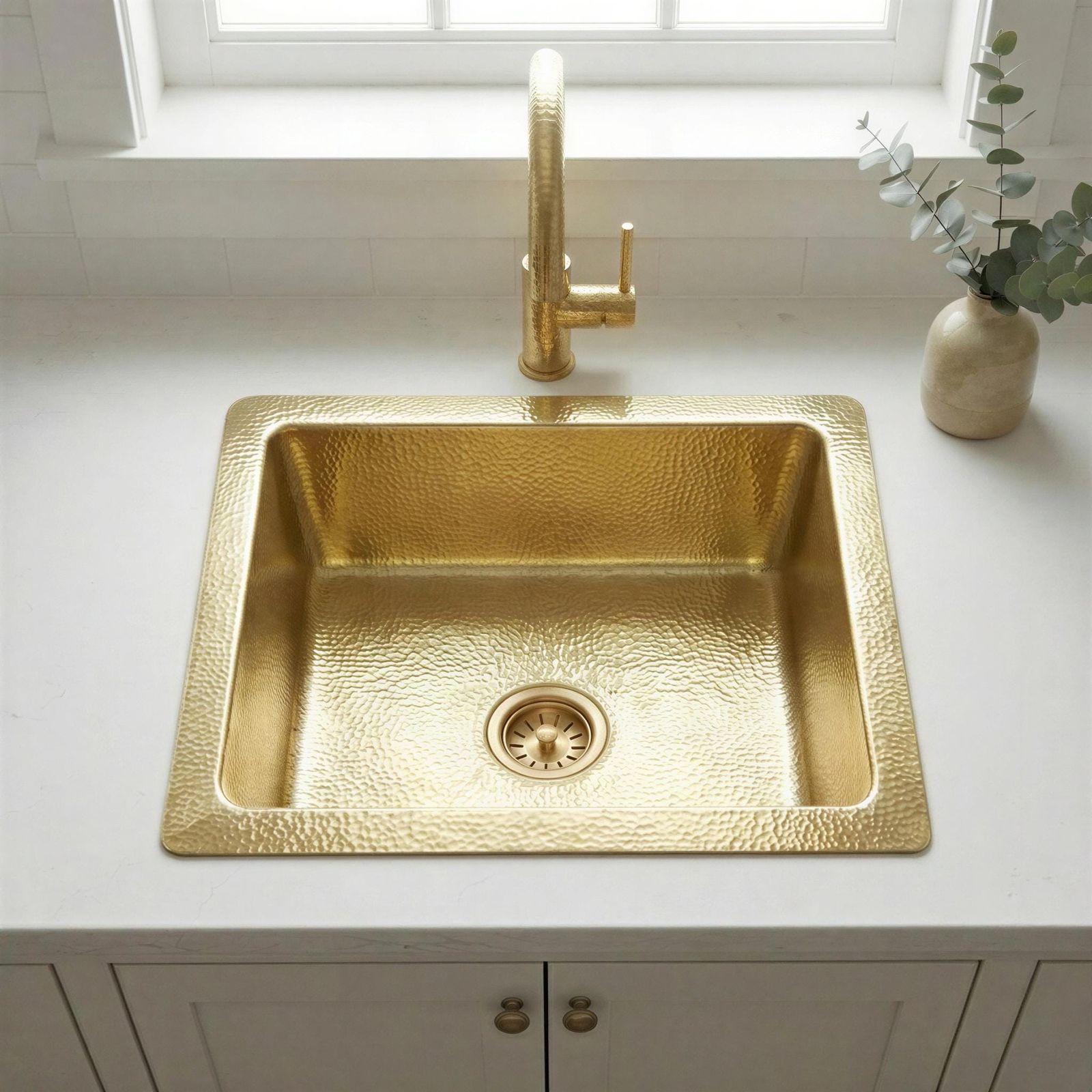 Gold kitchen sink with faucet on a white countertop