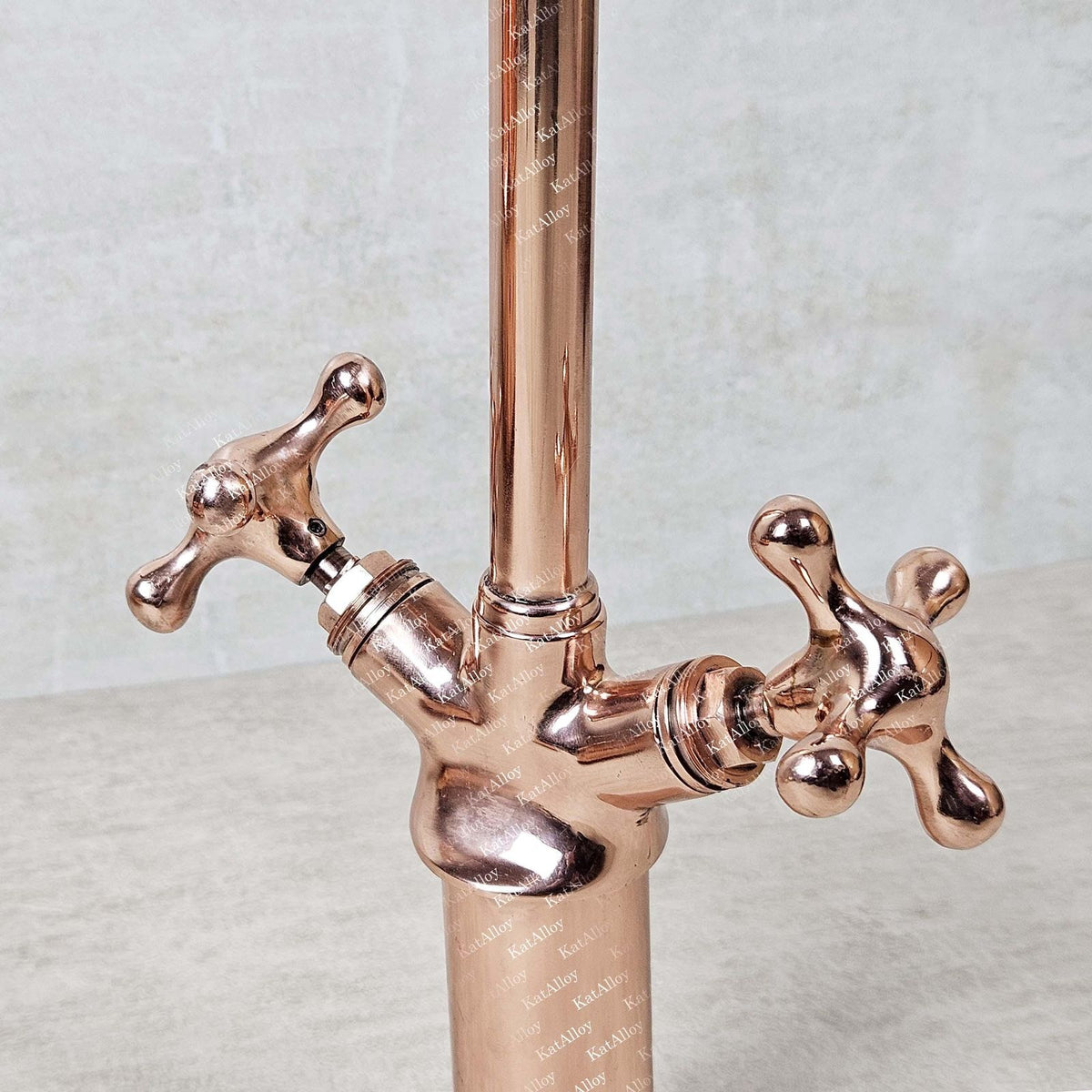 Rose gold faucet with two handles on a light background