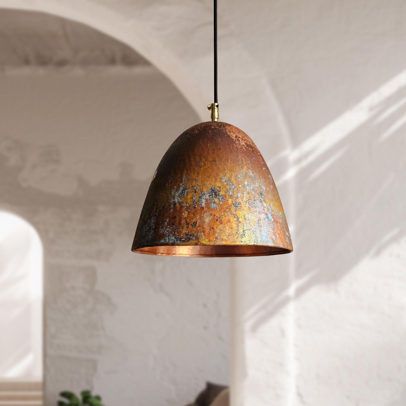 Rust-colored pendant light hanging against a neutral wall.