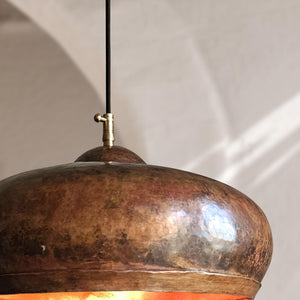 Close-up of a bronze pendant light with a blurred background