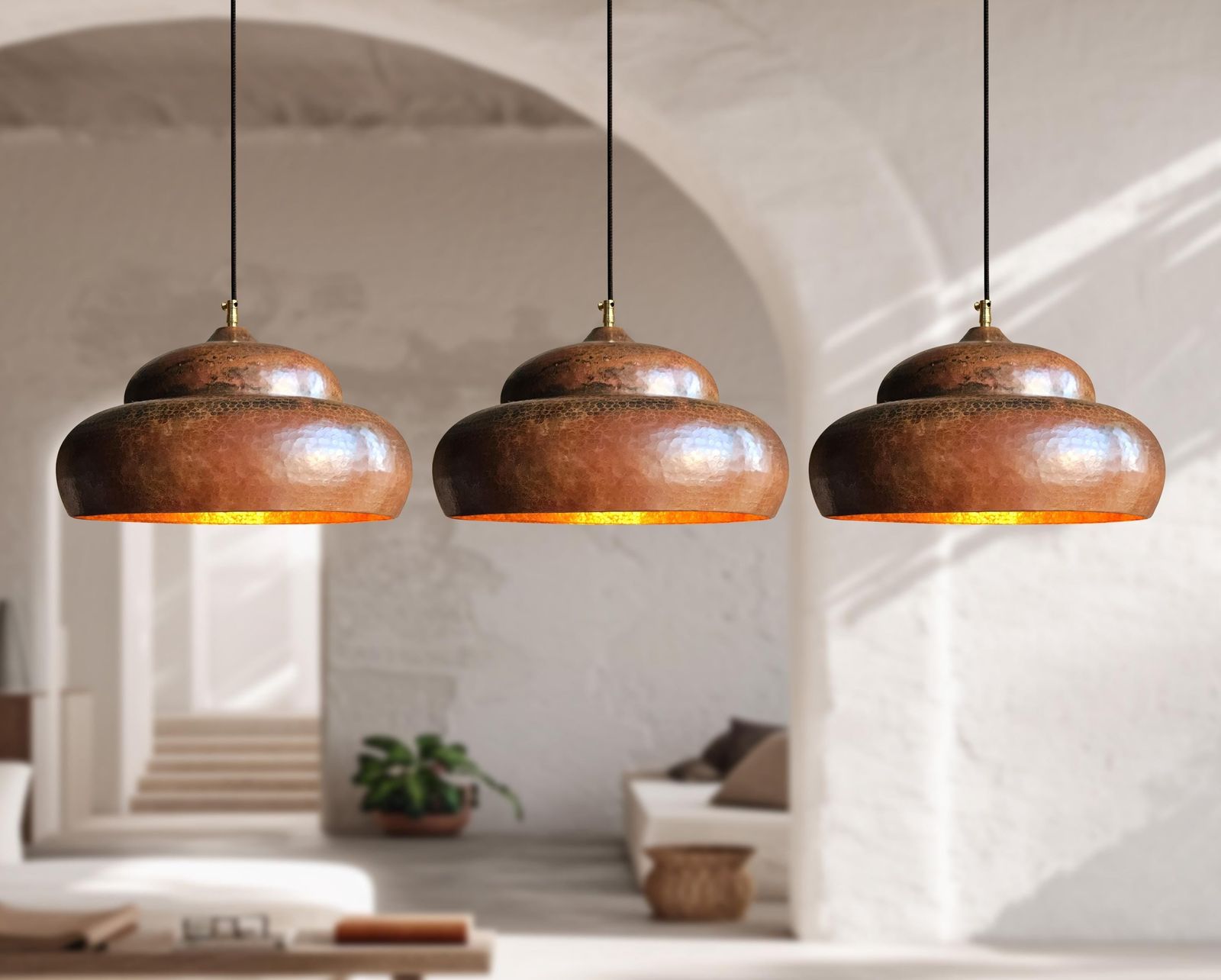 Three rustic pendant lights hanging in a room with a neutral color palette.