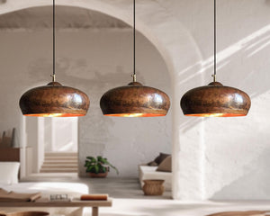 Three hanging copper pendant lights in a modern interior setting.