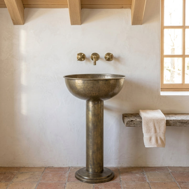 Front view of hammered antique brass pedestal basin and coordinating faucet