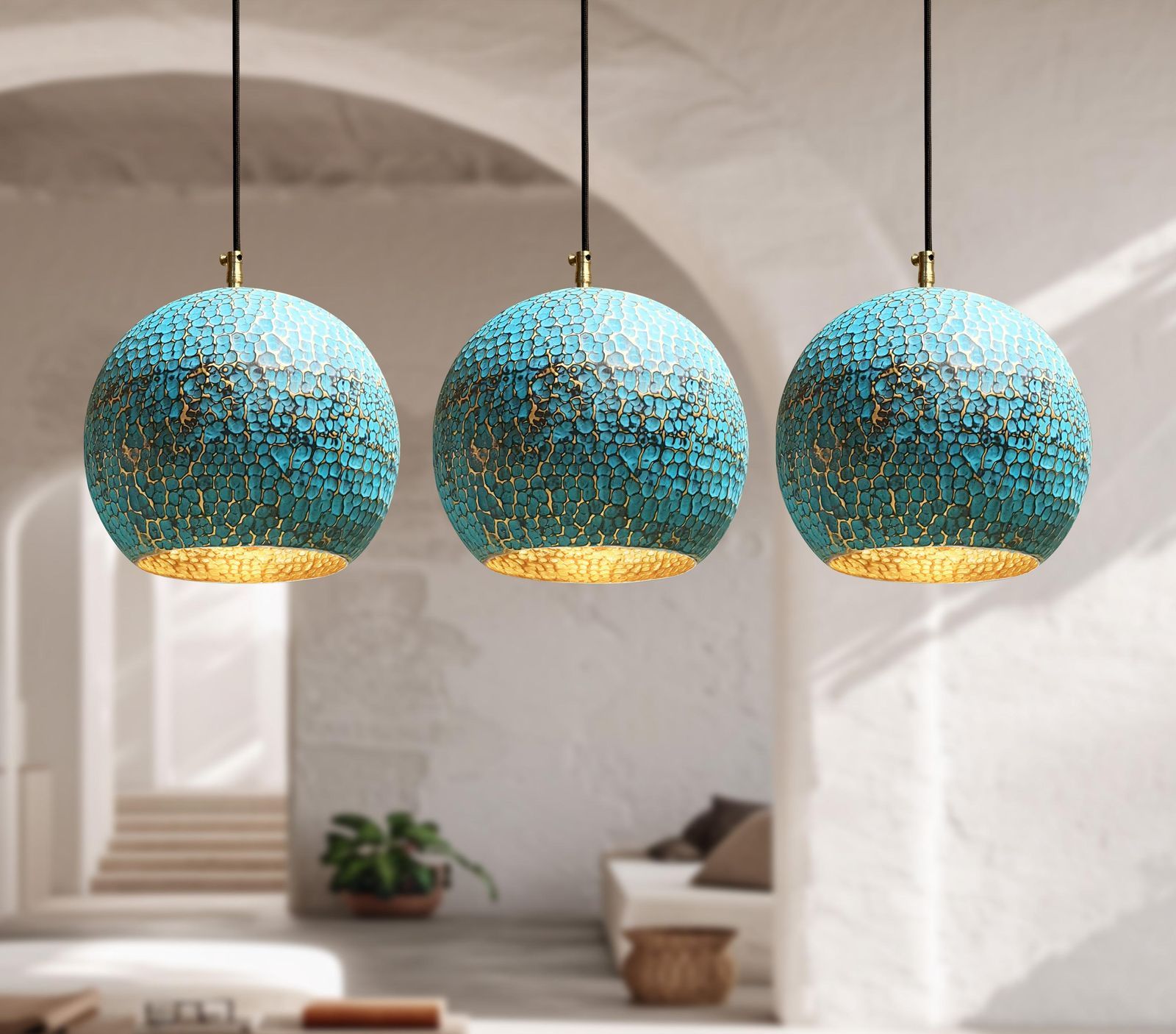 Three turquoise pendant lights hanging in a room with a neutral color palette.
