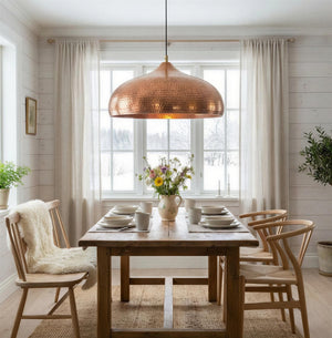 Dining room with wooden table, chairs, and a copper pendant light.