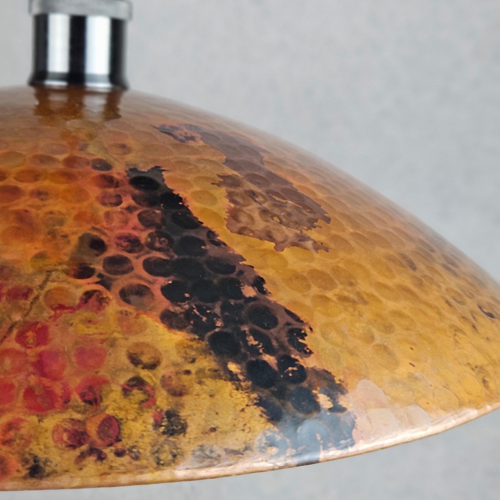 Close-up of a textured, multicolored dome-shaped object on a gray background