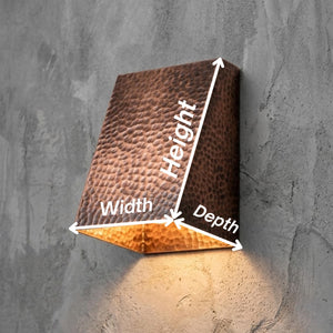 A wall-mounted rectangular light fixture with a hammered metallic finish, shown with white arrows and labels indicating width, height, and depth against a textured gray wall.
