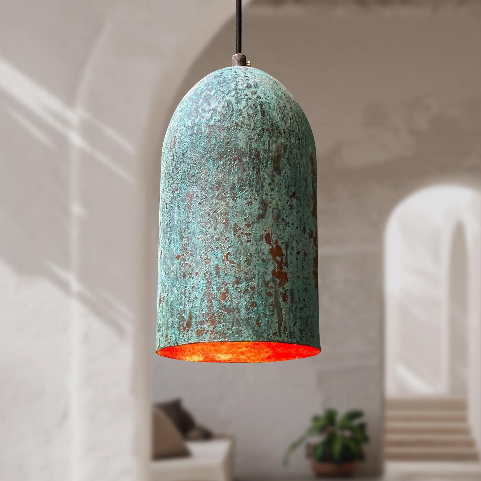 Turquoise pendant light with a warm glow in a softly blurred room setting