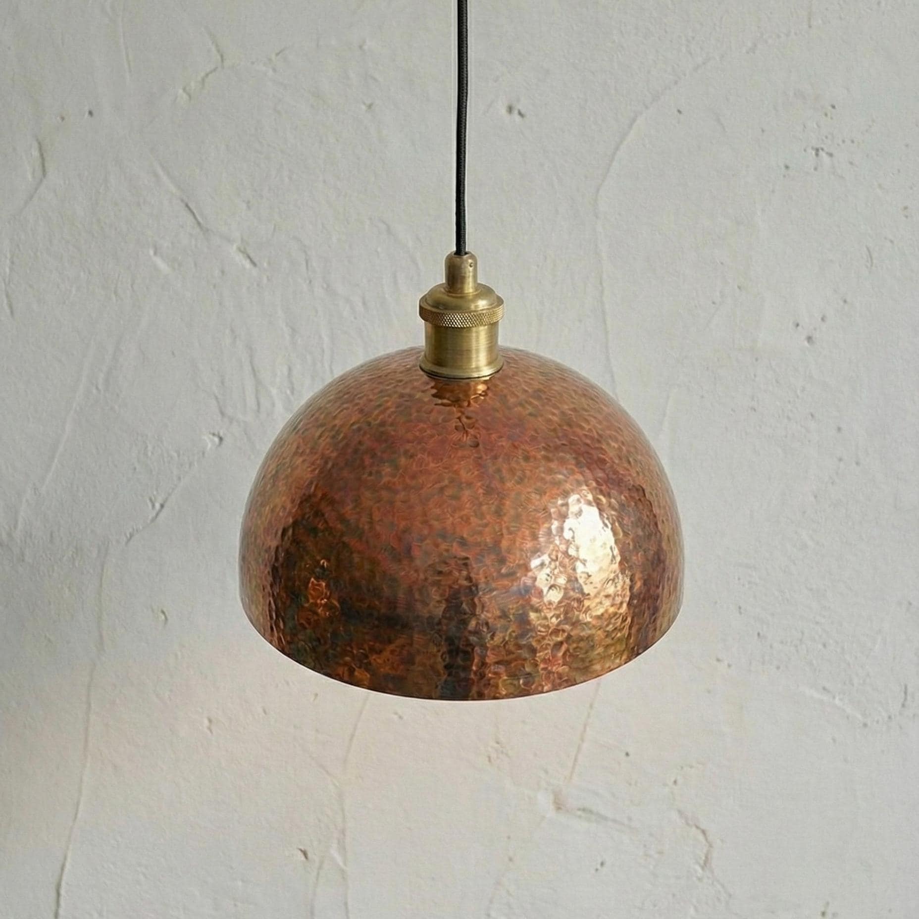 Copper pendant light with brass fitting on a white background