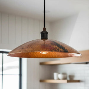 Copper pendant light hanging in a room with a blurred background