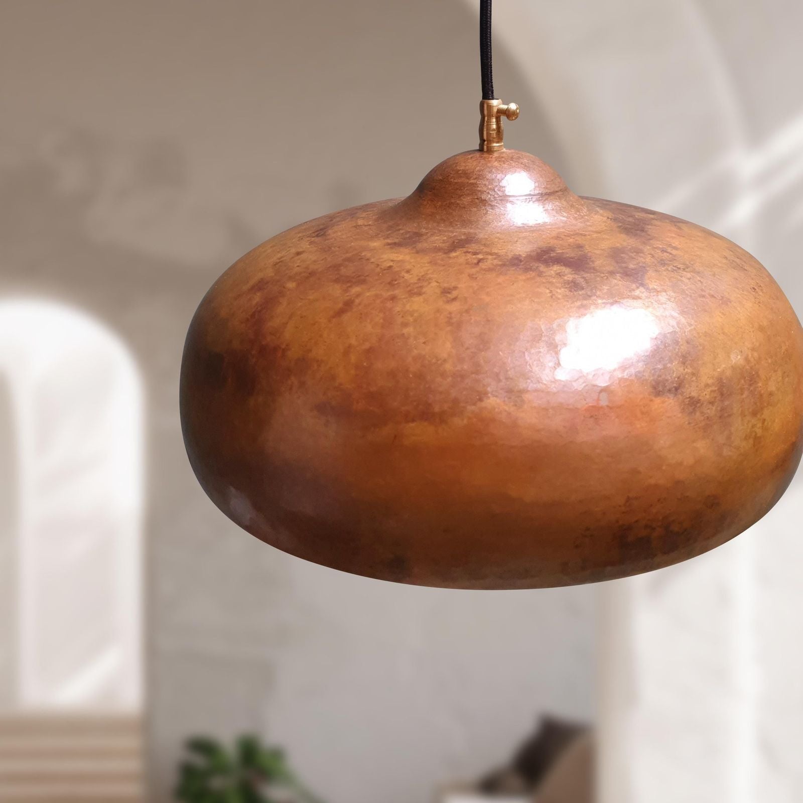 copper pendant light hanging against a neutral background