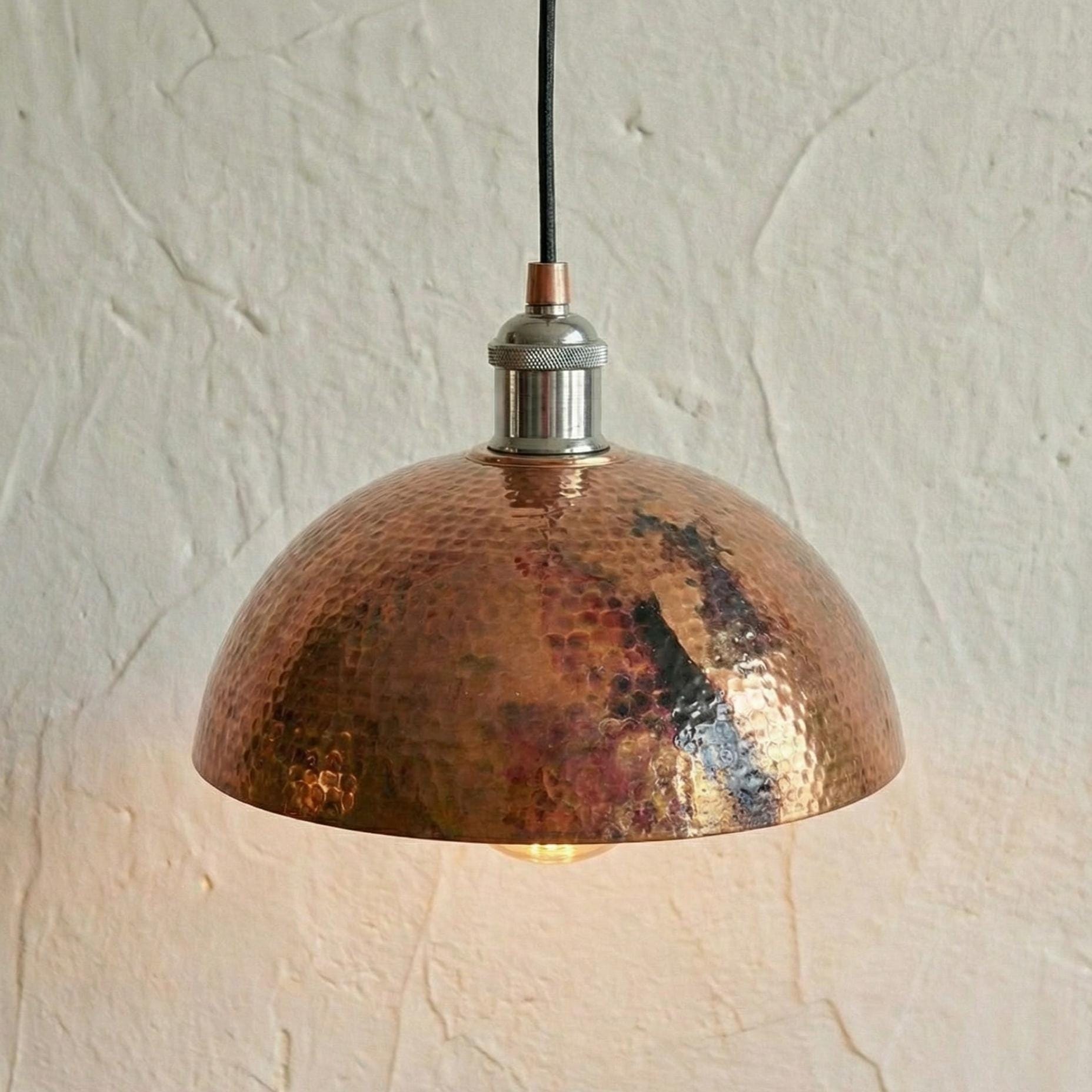 Copper pendant light with a textured finish on a neutral background