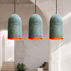 Three turquoise pendant lights with orange interior in a room setting.