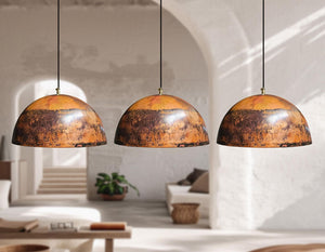 Three pendant lights hanging in a room with a neutral color palette.