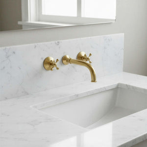 Gold faucet on a marble sink with a neutral background