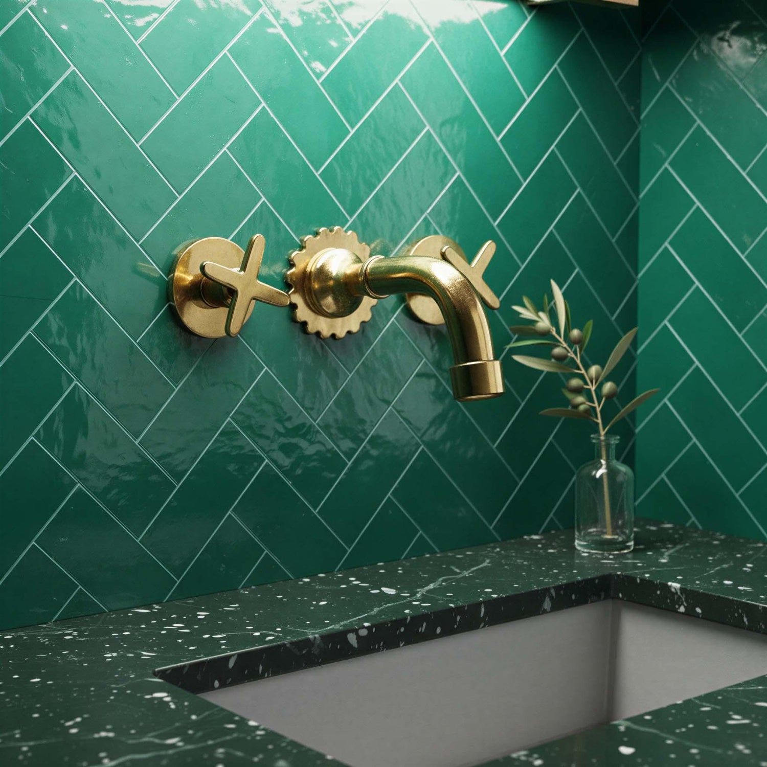 Gold faucet on a green tiled wall with a green countertop.