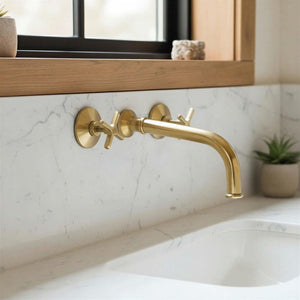 Gold faucet on a marble bathroom sink with a mirror above