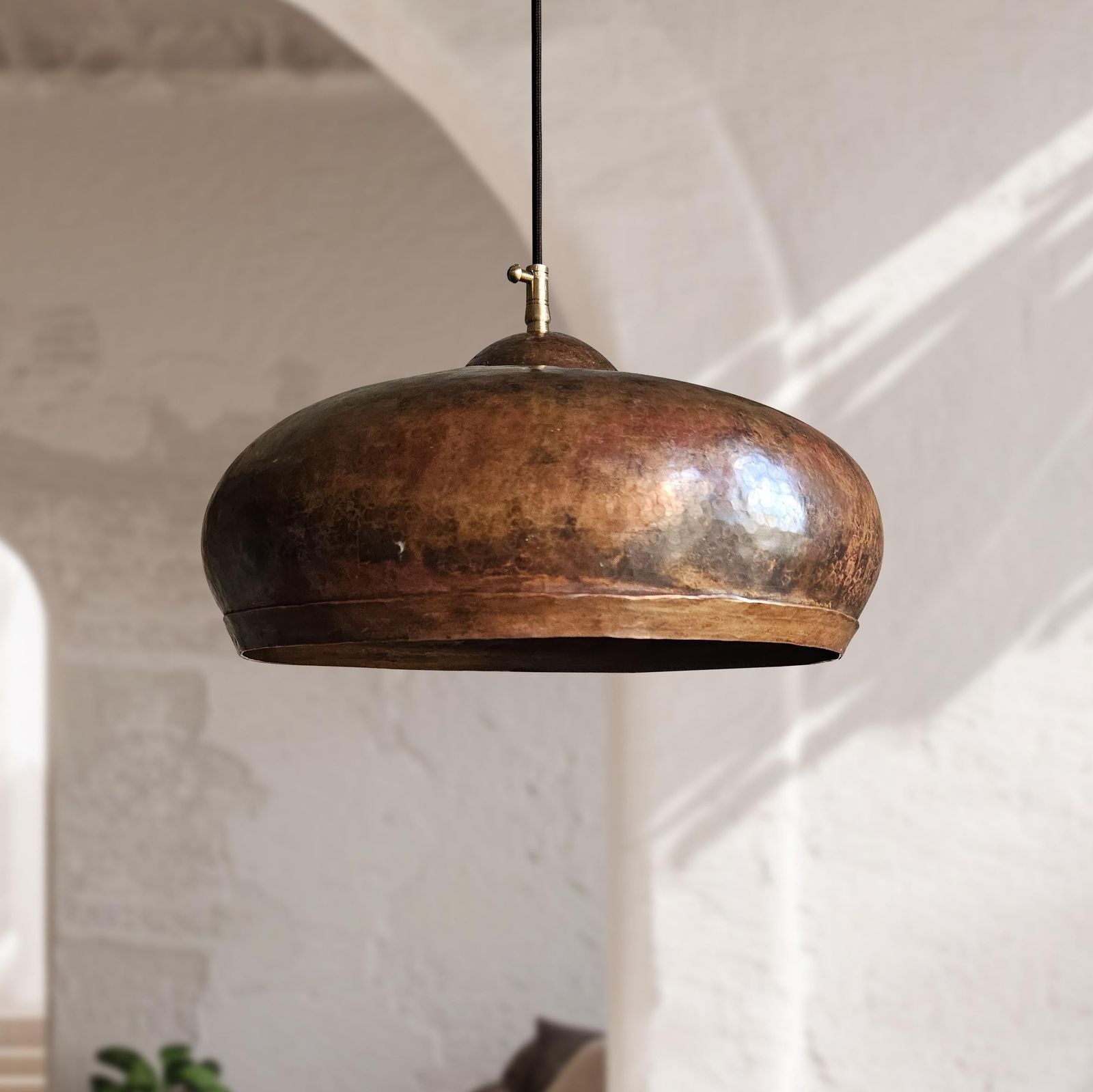Vintage-style pendant light hanging against a neutral wall.