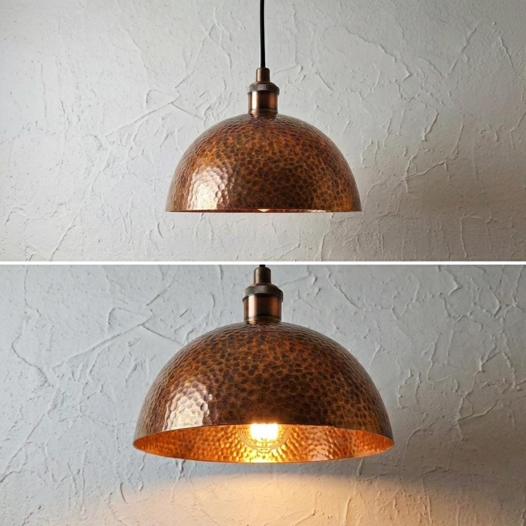 Copper pendant light fixture on a textured white wall.