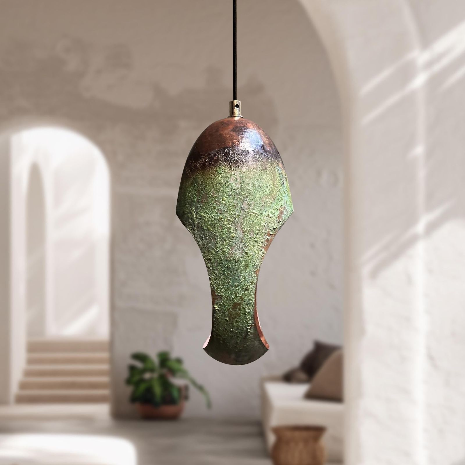 Decorative pendant light with a textured green and brown design hanging in a room.