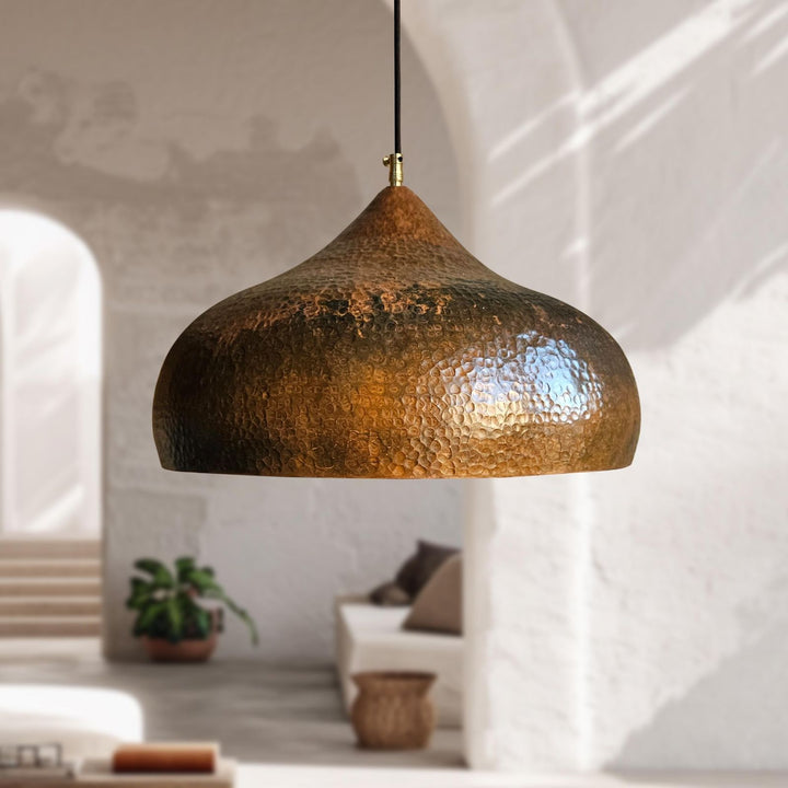 Bronze pendant light hanging in a room with a neutral color palette