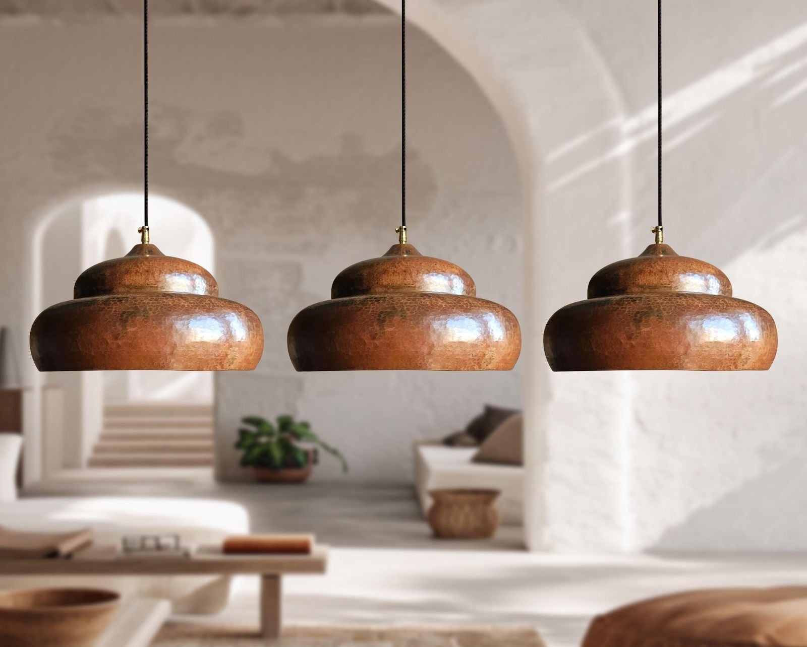 Three wooden pendant lights hanging in a room with a neutral color palette.
